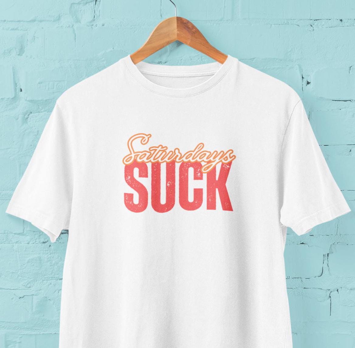 Saturdays SUCK Unisex Heavy Cotton Tee, Weekend Humor Graphic T-Shirt, Casual Tee, Relaxation Clothing, Gift for Him, Her, Unisex Tee Gift