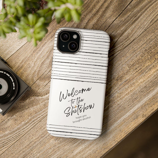 May include: A white phone case with black horizontal stripes. The case has the text &#39;Welcome to the Shitshow hope you brought alcohol&#39; printed on it.